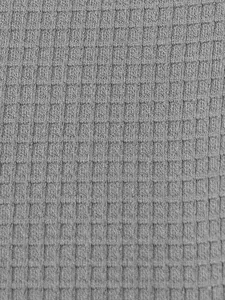 Macro detail shot of grey waffle knit fabric texture for men's casual Henley T-shirt