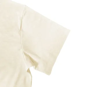 Detailed close-up view of the breathable slub cotton fabric texture on a cream T-shirt sleeve