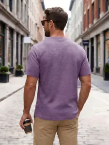 Back view of textured lavender short sleeve Henley shirt for men in urban setting