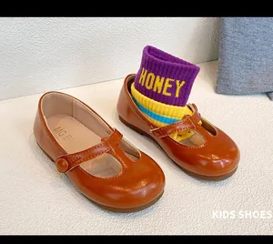 Detailed view of girls' brown leather T-strap Mary Jane shoes with flexible soft soles.