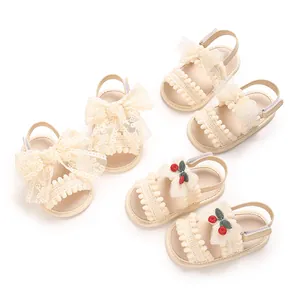 Vue rapprochée de sandales crème pour bébé fille avec nœuds en dentelle et cerises.