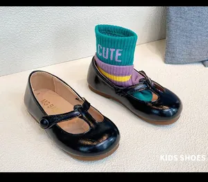 Detail of black patent leather Mary Jane shoes for girls with colorful sock prop.