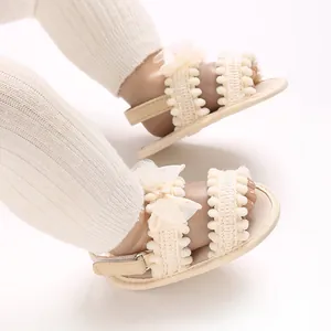 Vue détaillée de sandales bébé crème avec nœuds en dentelle et brides tissées souples