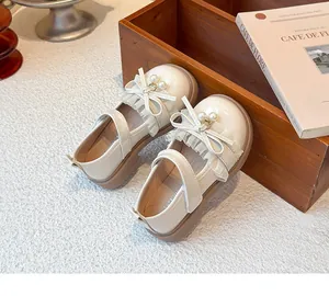 Detailansicht der cremefarbenen Prinzessinnenschuhe mit Rüschenschleife und Perlen