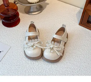 Detailansicht süßer Mädchen-Prinzessin-Flats in Off-White mit Spitzenschleife und Perlen