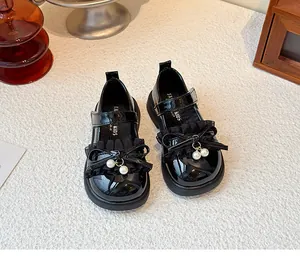 Nahaufnahme von schwarzen Lackleder-Mary Janes für Mädchen mit Rüschen und Schleife