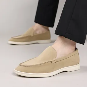 Gedetailleerde close-up van beige suède loafers voor heren met elegante gestikte details.