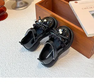 Detailansicht schwarzer Lacklederschuhe für Mädchen mit Schleife und Perlen.