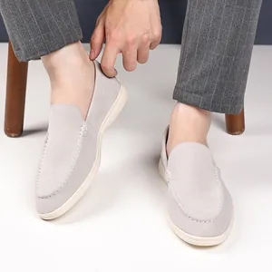Detailed view of comfortable grey suede slip-on loafers with decorative white stitching