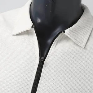 Détail du tissu gaufré blanc et de la fermeture éclair noire sur veste homme