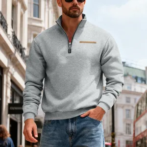 Detailed view of grey heavy fleece half-zip sweatshirt on male model in urban setting.