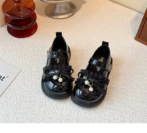 Detail von schwarzen Lackleder-Prinzessinenschuhen für Mädchen mit Rüschen und Perlen.