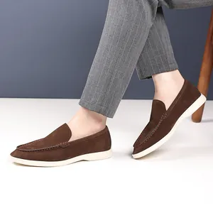 Gros plan détaillé de mocassins en daim marron classique avec semelles et coutures blanches.