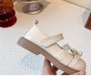 Detailansicht der eleganten cremefarbenen Mädchen-Mary-Jane-Lederschuhe mit Spitzenrüschen und Perle