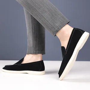 Close-up of men's black suede loafers worn with grey pinstripe trousers.