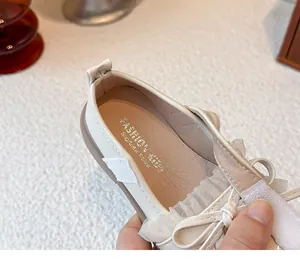Nahaufnahme der cremefarbenen Mädchen-Prinzessinenschuhe mit Rüschenschleife und Klett