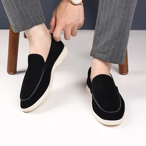 Detailed macro view of black suede slip-on loafers featuring contrast white rubber sole