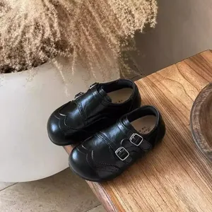 Gros plan de mocassins en cuir noir pour filles avec boucles et brogue