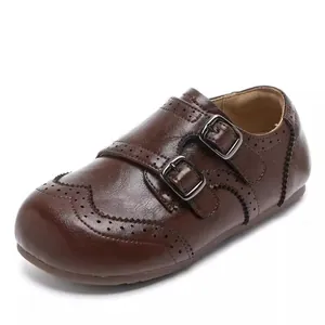 Détail de chaussures en cuir marron pour filles avec perforations et doubles boucles.