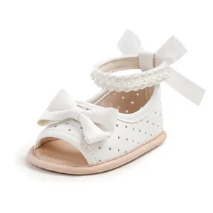 Vue détaillée des sandales blanches pour bébés filles avec des perles et un joli nœud