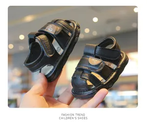 Macro view of black closed-toe baby sandals featuring adjustable bear velcro straps