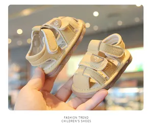 Close-up of beige baby sandals with velcro straps and cute bear detail