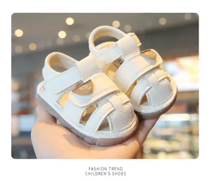 Detailed view of white baby closed-toe sandals with cute bear decor and soft soles