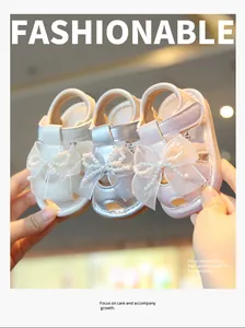 Macro view of baby girl princess sandals in white silver and pink with pearl bow