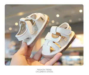 Close-up of cream toddler sandals with cute cartoon bear and soft anti-slip soles
