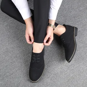 Top-down detail of black suede Brogue shoes with intricate decorative perforations