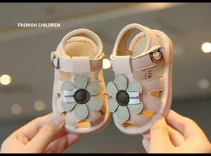 Close-up of pink hollow baby girl sandals with flower detail and soft sole
