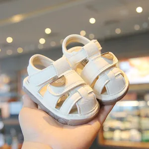 White soft-sole baby walking sandals with closed-toe design and cute bear detail.