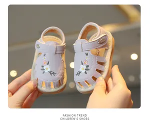 Detailopname van deze geborduurde peutersandalen met bloemmotieven en zachte zolen