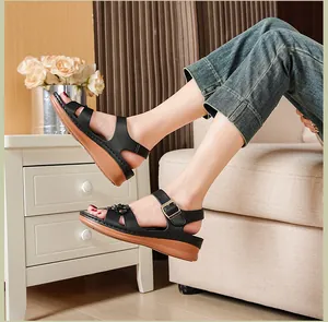 Detailed view of comfortable black wedge sandals with elegant flower accents worn by a model