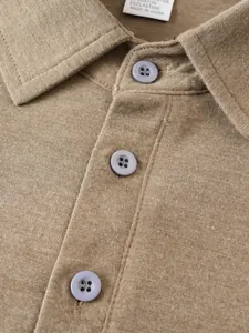 Close-up of a men's brown polo shirt collar featuring buttons and textured knit fabric