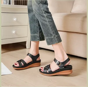 Detail view of black women's wedge sandals with floral accents and buckle strap.