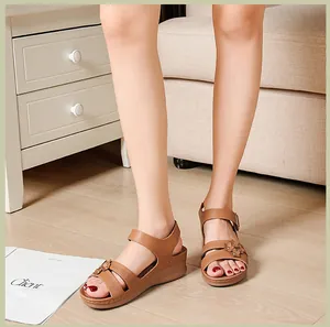 Detailed view of women's brown wedge sandals featuring flower accents and buckle strap