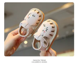 Detailweergave van roze geborduurde peutersandalen met schattige bloemmotieven voor meisjes