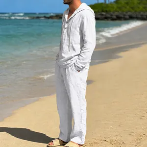 Ganzkörperansicht eines Mannes in einem weißen Leinenanzug an einem sonnigen Strand
