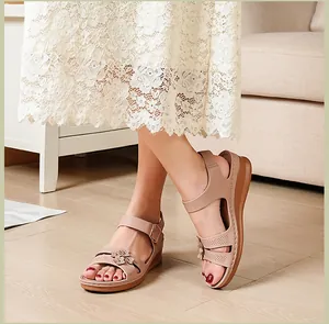 Detail view of elegant nude wedge sandals featuring floral accents and fine stitch detailing.