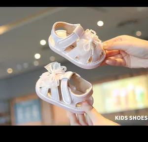 Close-up view of pink toddler girls' sandals featuring elegant pearl bows and soft soles