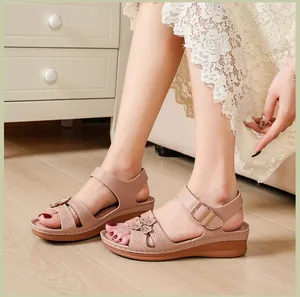 Close-up of nude pink wedge sandals for women with flower details and cutout design