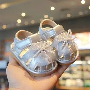 Elegant silver baby girl sandals featuring a pearl bow and soft anti-slip rubber sole