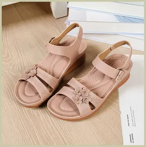 Detail of beige wedge sandals for women with elegant floral decorations and stitching