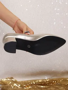 Detail view of black anti-slip sole and size 37 mark on silver chunky heel pumps.