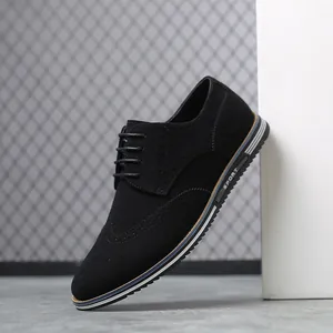Gros plan de chaussures richelieu en daim noir avec détails sculptés et semelle sport