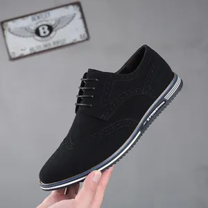 Gros plan sur une chaussure Brogue en daim noir avec motifs perforés classiques.