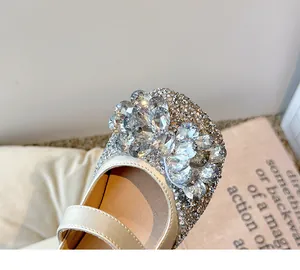 Gros plan sur un nœud en strass étincelant sur des chaussures de princesse pour fille.