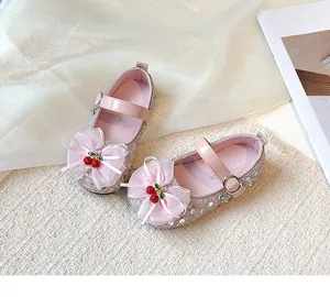 Detailed view of pink sparkling girl shoes with mesh bow and cherry decor