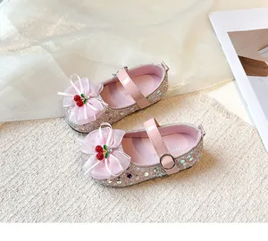 Close-up of pink glitter Mary Jane shoes with mesh bow and cherry charm